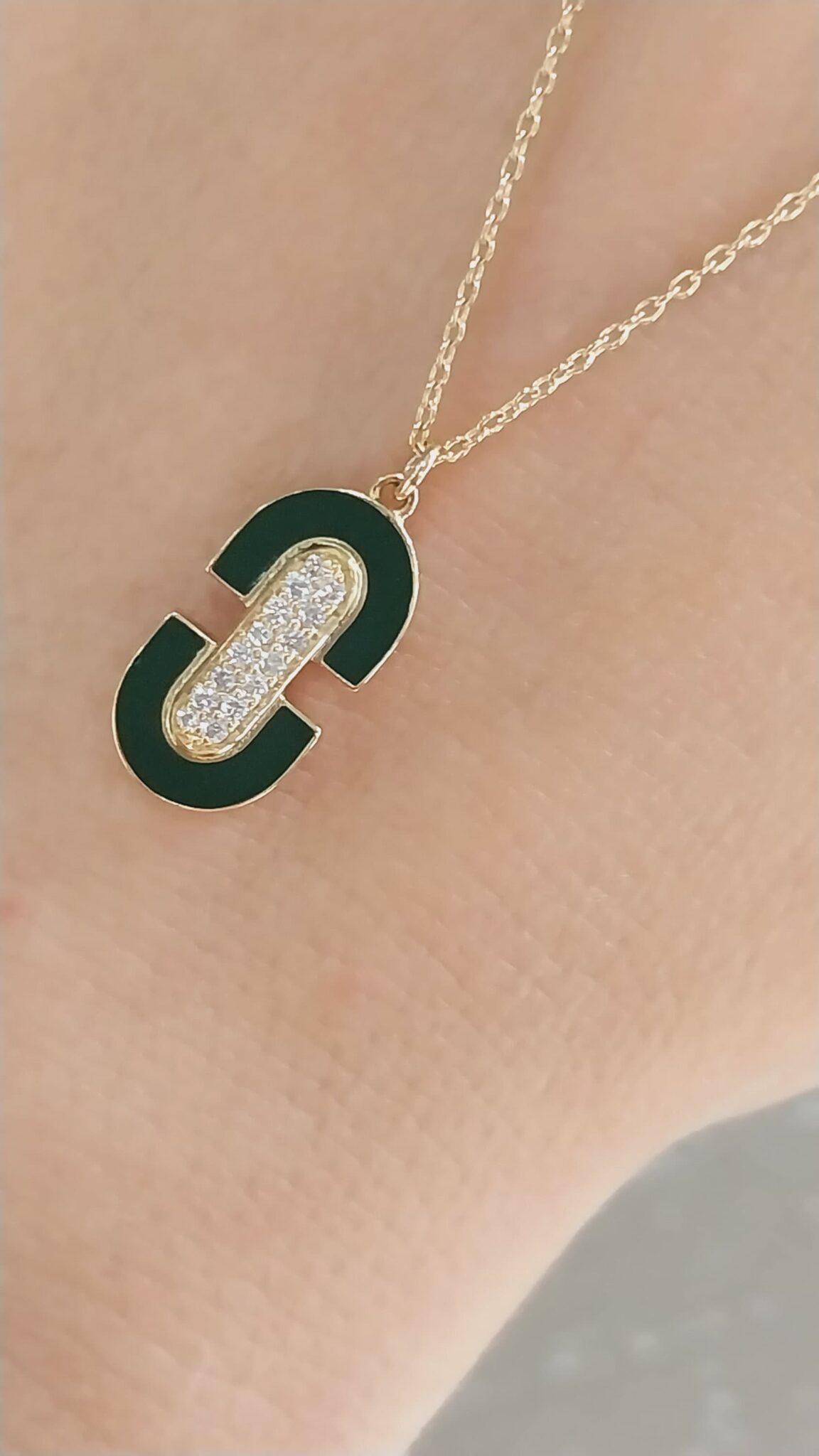 Emerald Oasis the idea of a lush, vibrant oasis in the desert, with the green enamel representing the emerald green of the oasis. | Green Gem Glow the radiant green enamel and the sparkling diamonds, emphasizing the necklace's luminous quality. | Oval Elegance: Simple and straightforward, the classic, sophisticated style of the oval shape. | Green Goddess the necklace is a symbol of femininity and beauty, with the green enamel representing fertility and abundance. | Luminous Leaf: This title plays off the idea of the green enamel leaf design, emphasizing its radiant quality.| Oval Opulence combines the luxurious feel of gold and diamonds with the elegant shape of the oval.